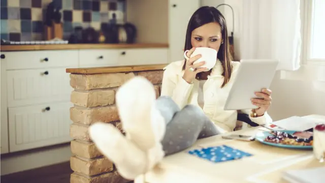 Mujer relajándose usando una tableta sobre la mesa
