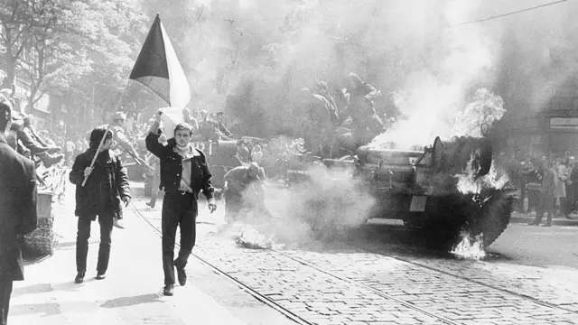 Чешские студенты с флагом возле горящего танка.