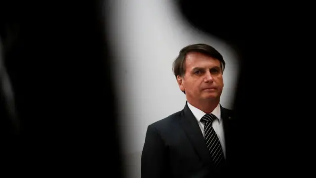 O presidente Jair Bolsonaro apareceaposta esportiva cursopé, olhando para frente