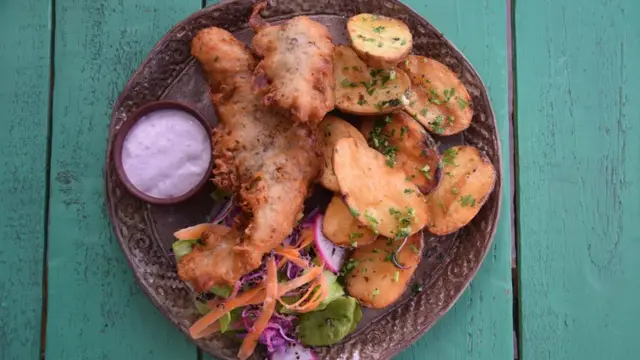 Pescado frito con papas nativas, aderezadas con una salsa a base de maqui.