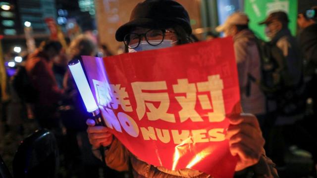 日本反核示威者在東京電力公司東京總部外舉起「反對原發」標語牌（11/3/2021）