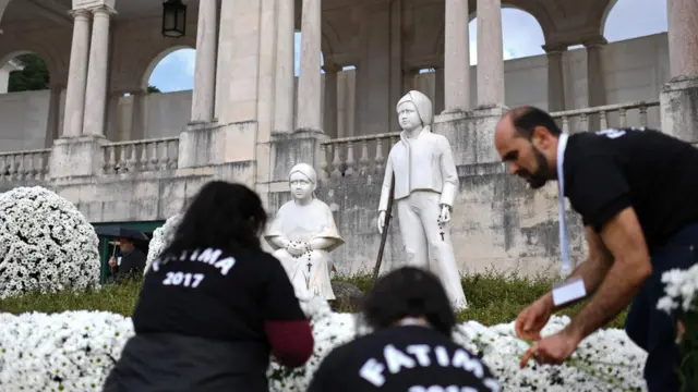 Паломники возлагают цветы к статуям будущих святых