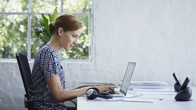 Mujer sentada frente a una laptop