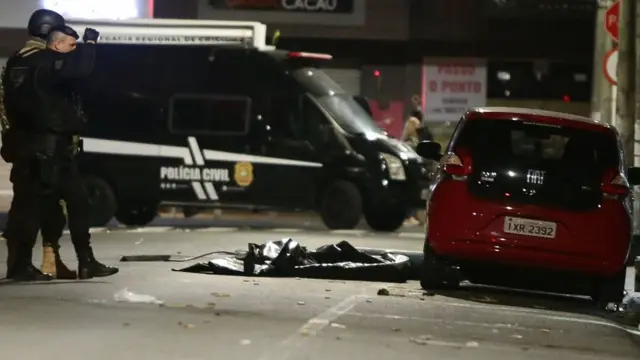 Policiais em volta de uma área onde um dos explosivos foi colocado