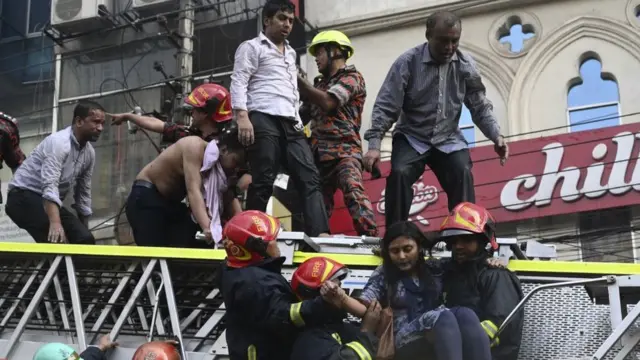 ভবনের ভেতর থেকে লোকজনকে বের করে আনছেন ফায়ার সার্ভিসের কর্মীরা