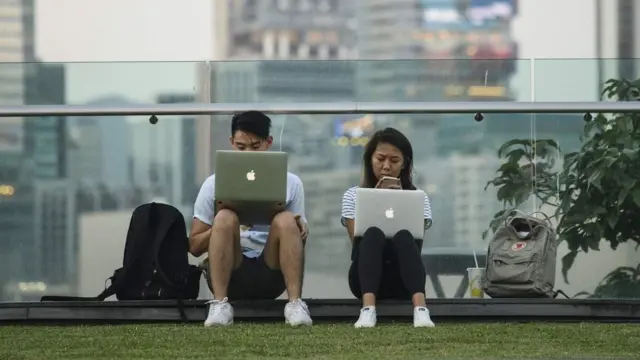 香港添马公园一对男女席地而坐查看笔记本电脑(11/10/2017)