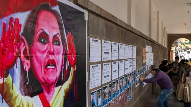 Cartel con Dina Boluarte con sus manos ensangrentadas en la ciudad de Juliaca.