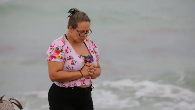 Joven reza en la playa frente al edificio Champlain Towers South