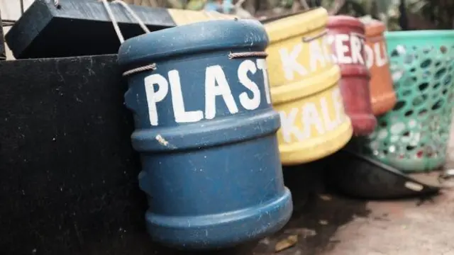 Memilah tempat sampah dengan galon bekas.