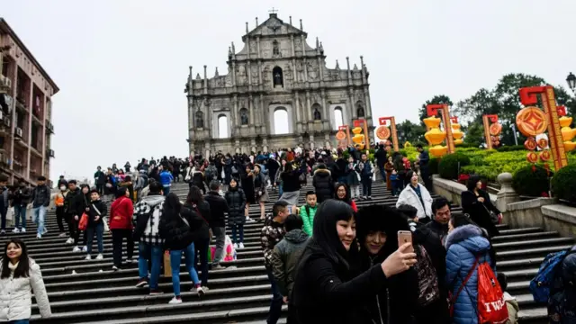 游客在澳门大三巴牌坊拍照(资料图片)