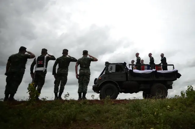 เจ้าหน้าที่ทหารแสดงความเคารพขณะขบวนเคลื่อนศพผ่าน