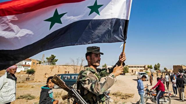 叙利亚库尔德政党和武装力量跟大马士革达成协议后，叙利亚政府军从各个营地开拔，向土耳其边境进发。军人打出了叙利亚国旗。