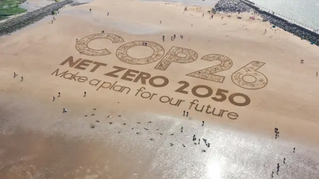 Imagem gravada na areiasorteio numeros roletauma praia na Inglaterra que diz 'COP 26, emissões líquidas zerosorteio numeros roleta2050, façam um plano para o nosso futuro'