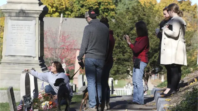 Mujeres dejando ofrendas en la tumba de Anthony.