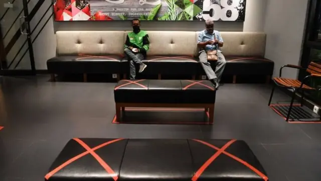 Pelanggan duduk berjarak saat menunggu makanan pesanannya di sebuah restoran cepat saji di Surabaya, Jawa Timur, Senin (06/04/20).