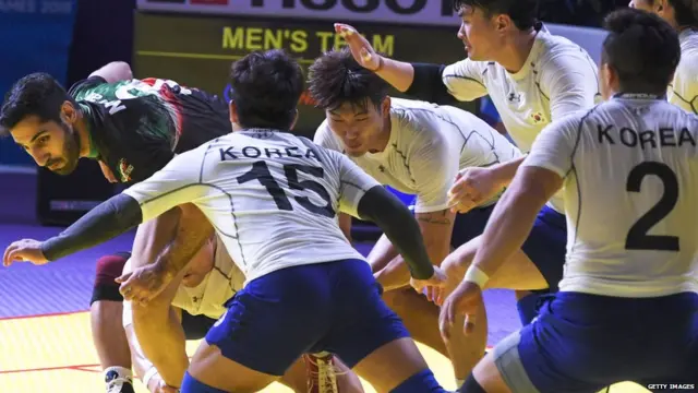 Iran's Mohammadamin Nosrati (L) competes against South Korea's players during the of kabaddi men's team final match at the 2018 Asian Games in Jakart