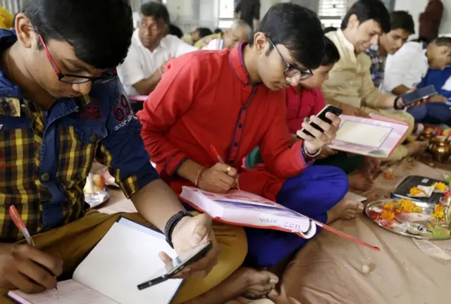 2017માં મોબાઇલ સાથે ચોપડા પૂજન કરતા વેપારીઓની તસવીર