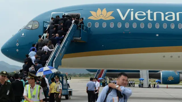 Vietnamese officials walk up into an Airbus A350-900 XWB during a ceremony marking the reception of the first new Airbus A350-900 XWB by Vietnam Airlines at Hanoi's Noi Bai international airport on July 2, 2015