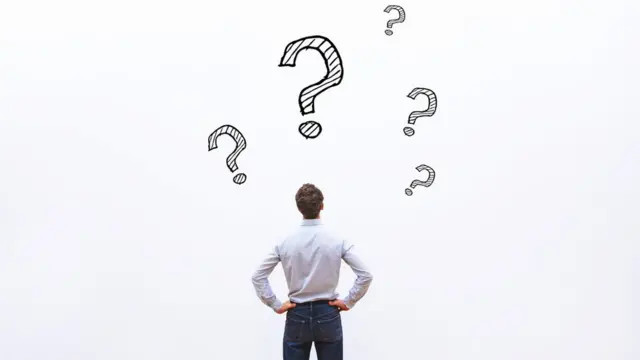 Hombre ante signos de preguntas.