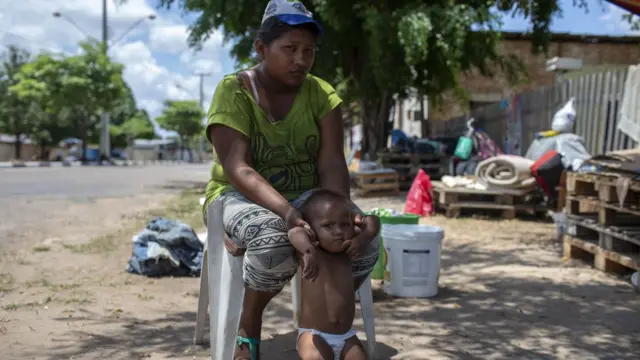 ব্রাজিলের রোরাইমা প্রদেশে রাস্তার পাশে ভেনেজুয়েলান মা ও শিশু, অগাস্ট ২৩