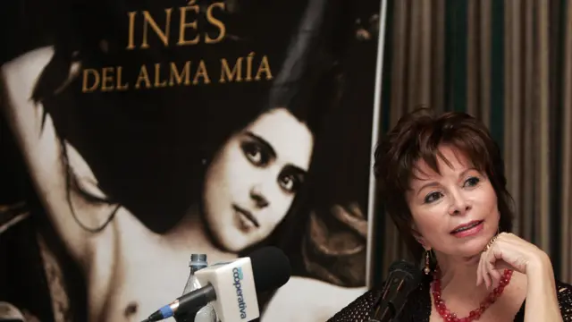 Isabel Allende junto a una imagen de la portada de su libro "Ines del alma mía"