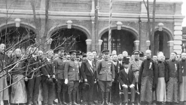 Henry Pu-Yi, former boy emperor of Japan, seated surrounded by dignitaries after the ceremony in which he was sworn in as ruler of the newly formed State of Manchukuo.