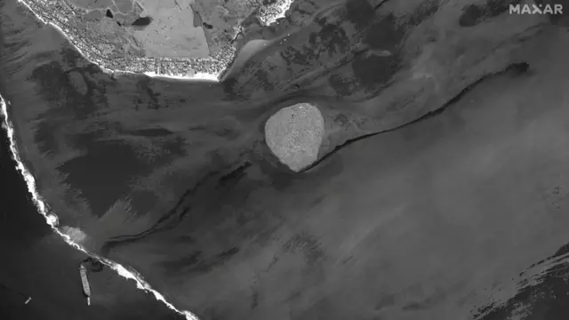 A satellite image shows the ship and the oil spill