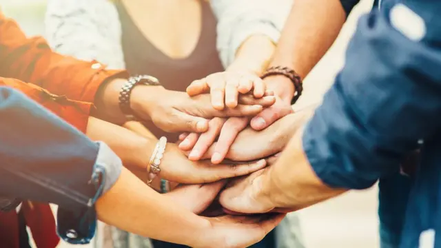 Grupo de amigos juntando las manos.
