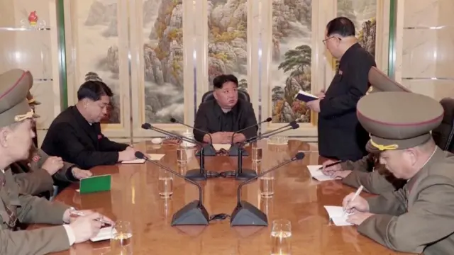 김정은 북한 국무위원장이 비공개 장소에서 관료들과 회의에 참석하고 있다