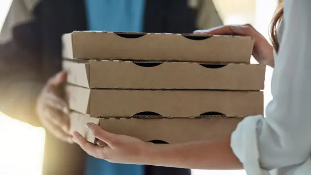 Hombre entrega cajas de pizza