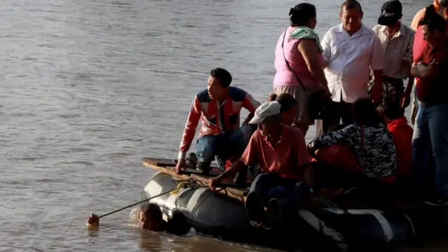 Personas cruzando de Guatemala a México a bordo de una balsa de goma