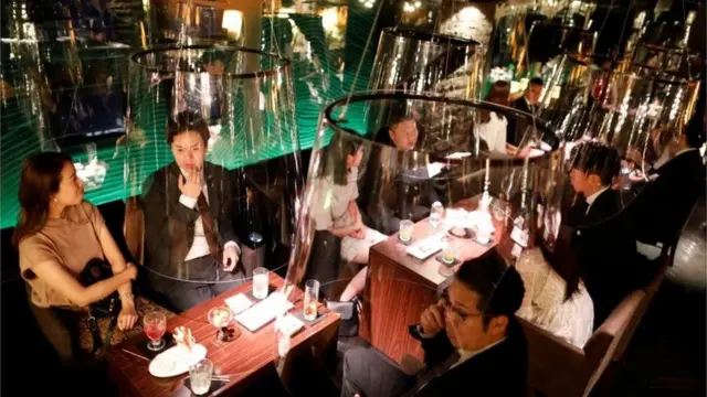 Goldfish bowl-like acrylic screens used as part of new social distancing measures and prevention of infection against the coronavirus disease