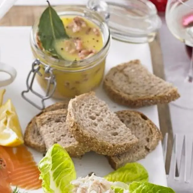 Креветки в горшочке с кусками хлеба и листьями цикория