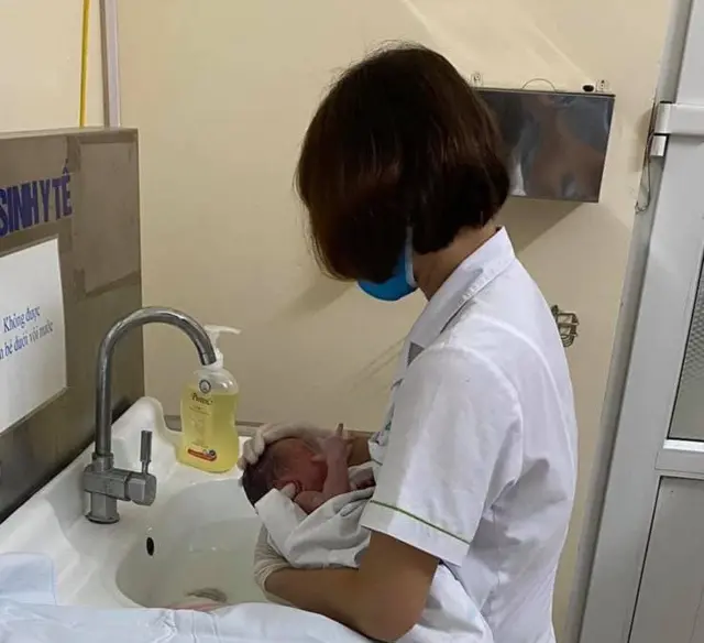 Cháu bé được chăm sóc sức khỏe tại trạm y tế