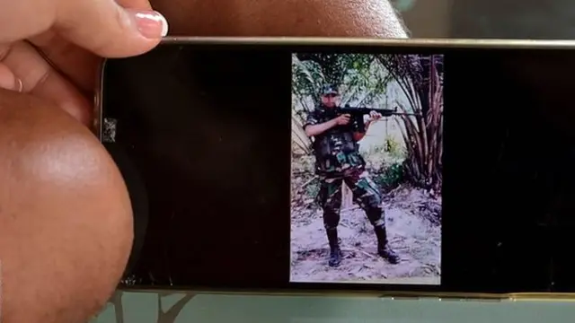Florian and his wife Angie show a photo of Florian as a soldier