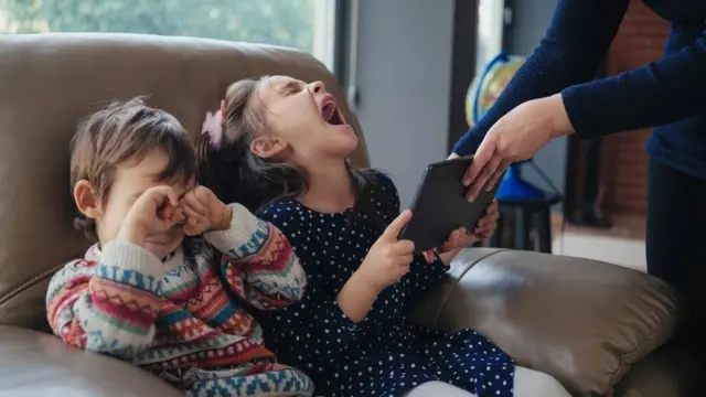 Una mujer limita el uso de redes sociales a dos niños en una imagen de archivo