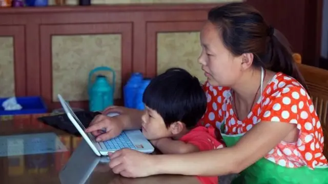 Una madre china y su hijo usando una laptop