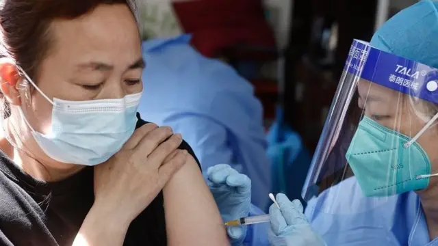 साङ्घाइमा बुस्टर खोप लगाउँदै महिला