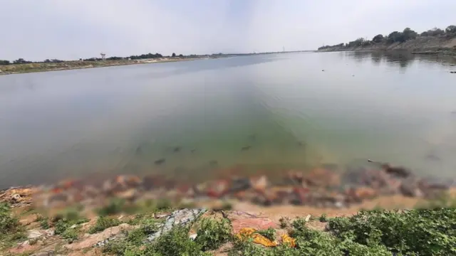 Blurred image of bodies floating in the Ganges and piling up on the river bank