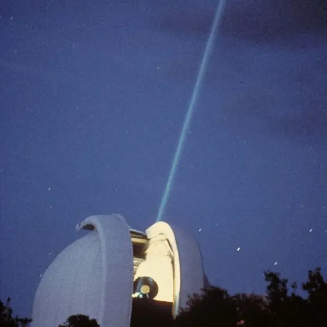 Telescopio del Observatorio McDonald enviando un rayo láser a la Luna
