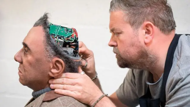 Pakar prostetik Mike Humphrey memeriksa Fred, robot Mesmer yang dibangun oleh Engineered Arts di Cornwall, Inggris