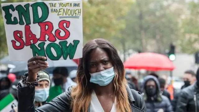 End SARS protester hold placard