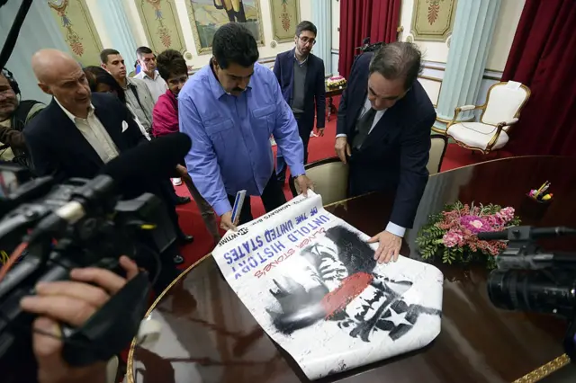 Оливер Стоун во время визита в Каракас дарит президенту Венесуэлы Николасу Мадуро рекламный плакат своего фильма "Нерассказанная история Соединенных Штатов". 11 декабря 2013 г.