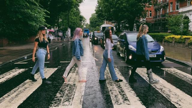 Jenna walks bare foot across Abbey road crossing.