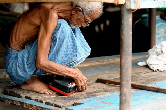 رجل مسن يصلح راديو