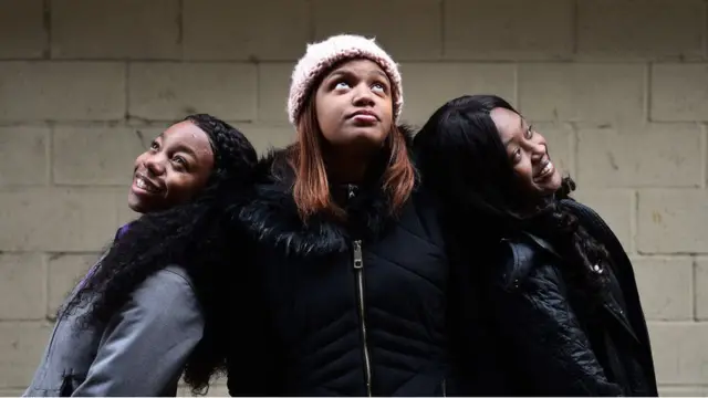 three black America girls pose for foto