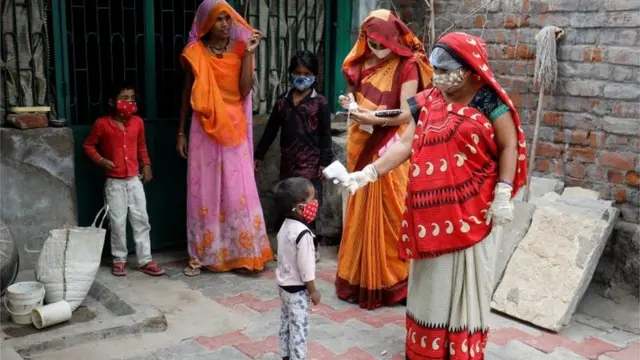 A healthcare worker checks the temperature of a child during a door-to-door surveillance to safeguard children amidst the spread of the coronavirus disease (COVID-19)