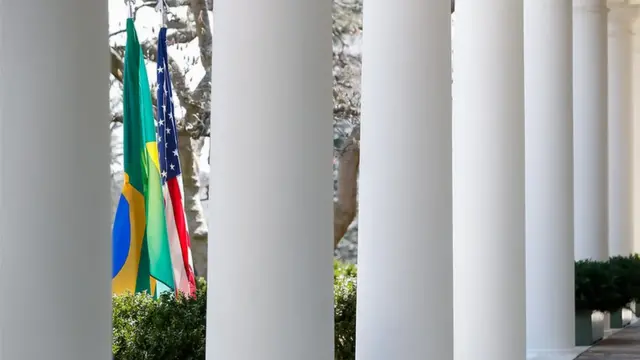 Bandeiras do Brasil e dos EUA entre colunas da Casa Branca