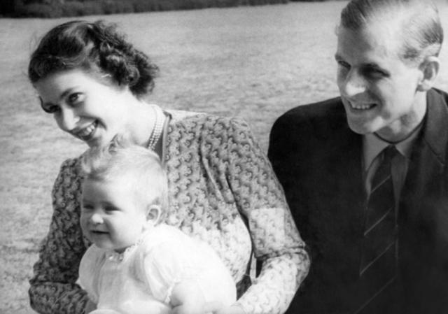 Princesa Elizabeth da Inglaterra e seu marido, príncipe Philip, duque de Edimburgo, com o bebê Charles em 1949 em Windlesham Moor, no condado de Surrey.