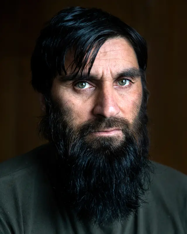A bearded man poses for a portrait